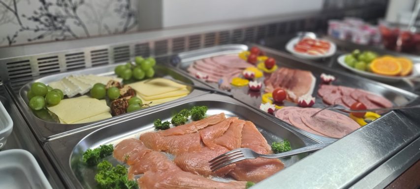 Buffet mit Wurst, Käse, Fisch, Trauben und verschiedenen Salaten.